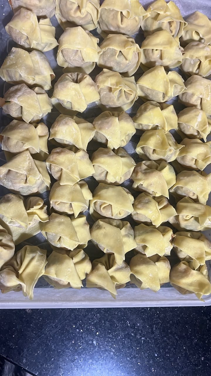 Freshly folded chicken dumplings before freezing